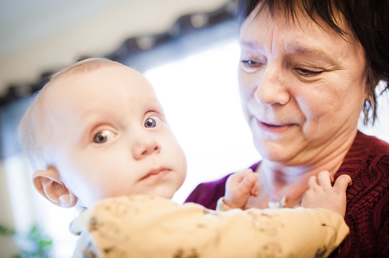 Mormor håller i sitt barnbarn