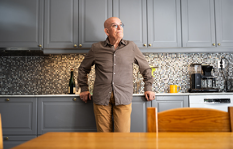 Ivars Jegers står i sitt kök och tittar ut mot fönstret.