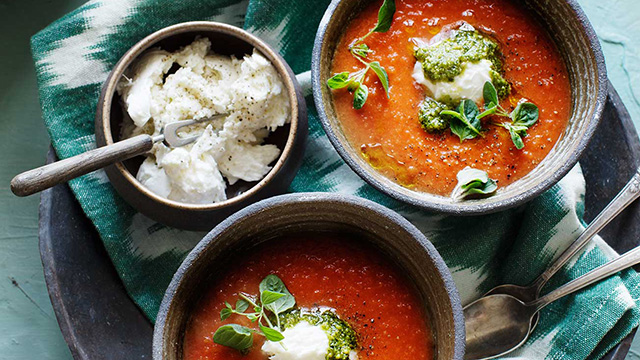 Tomatsoppa med bönor, mozzarella och pesto serverad i skålar på en bricka