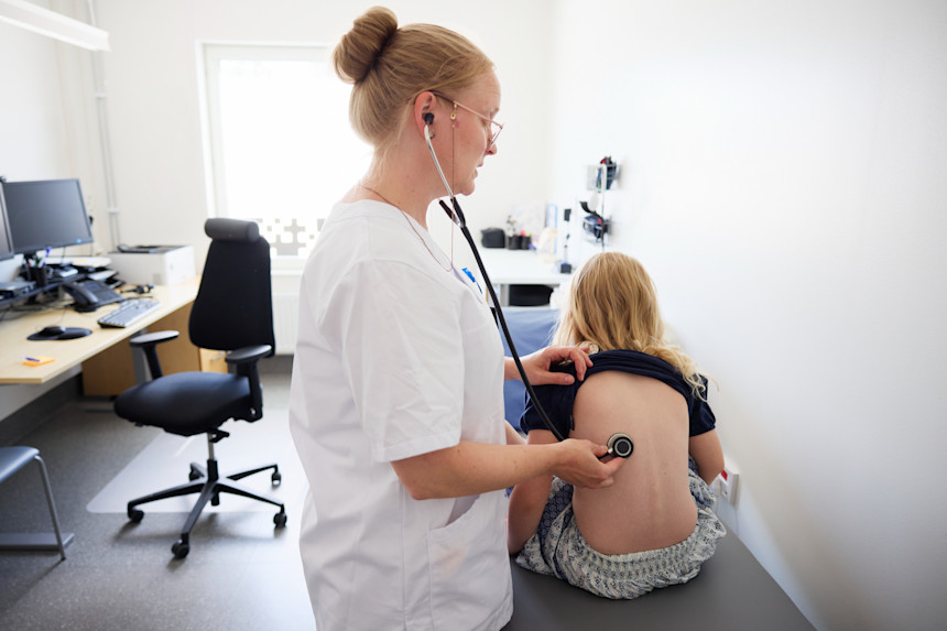 Doktor undersöker barn med stetoskop 