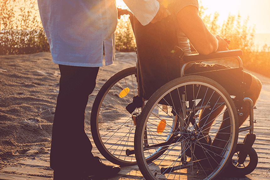 Anhörig person med sin närstående som sitter i rullstol