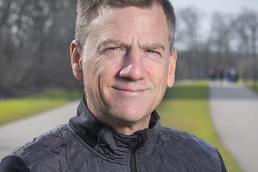 Olle Melander ler och tittar in i kameran, han är utomhus.