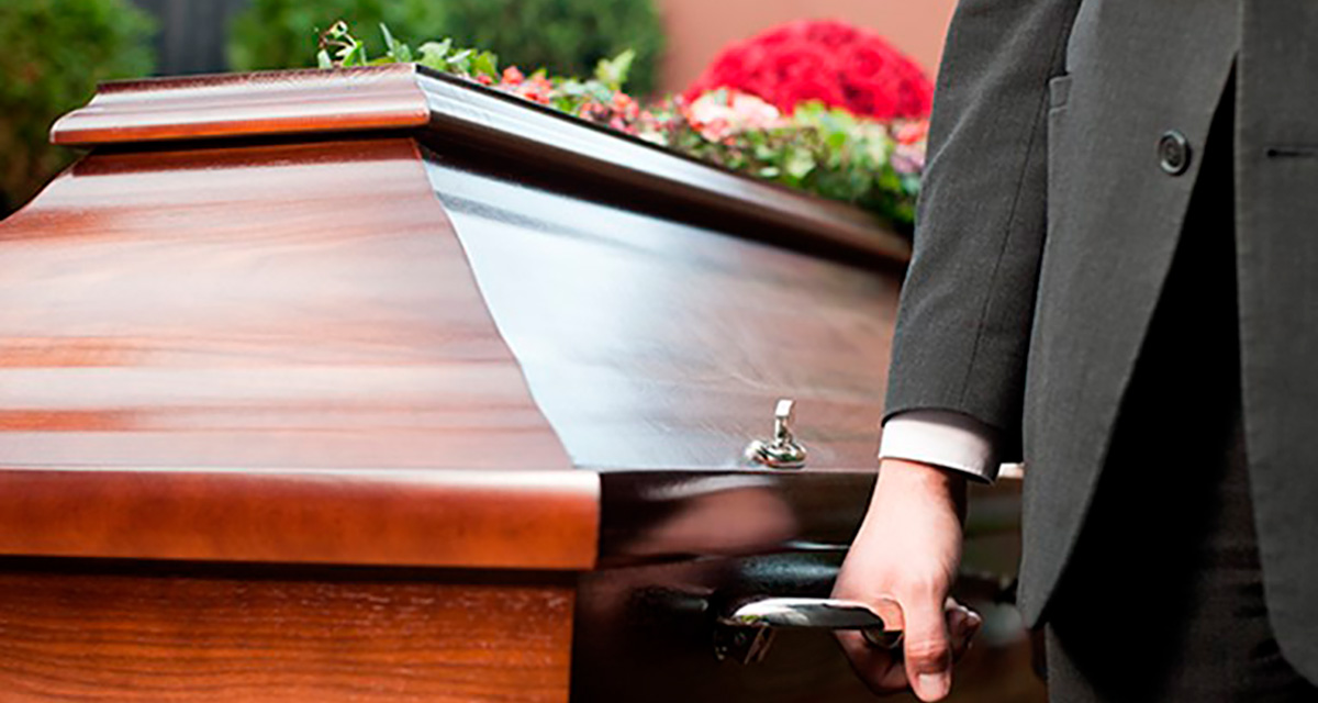 Man som håller i ett handtag på en kista.