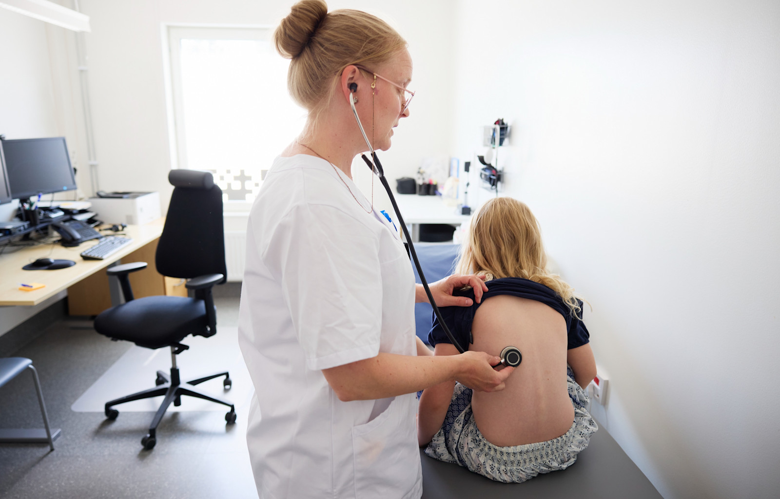 Doktor undersöker barn med stetoskop