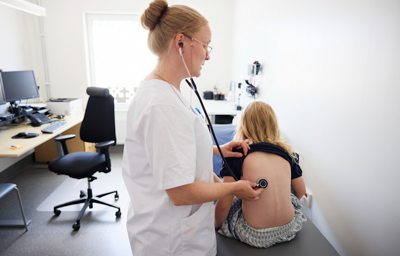 Doktor undersöker barn med stetoskop