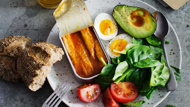 Ägg, avokado, tomater , spenat och bröd med mera på en tallrik.