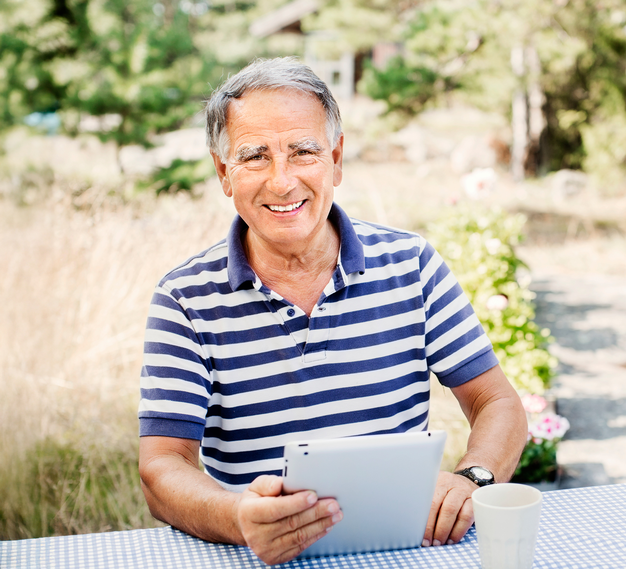 Man i trädgård i randig tröja.