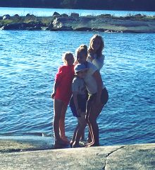 Fyra personer tillsammans på en klippa vid havet