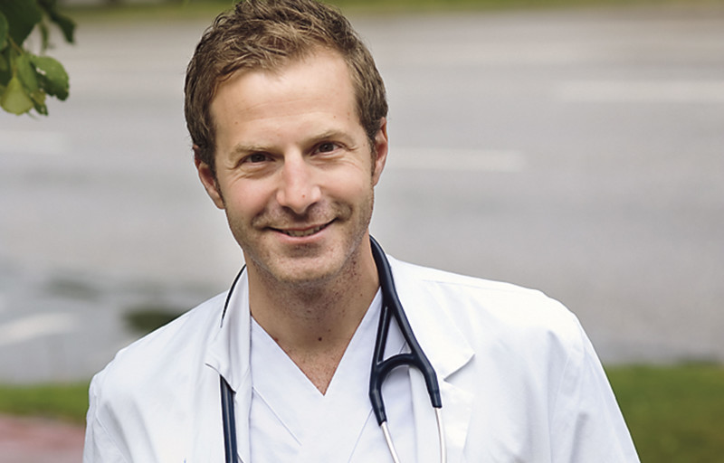 Manlig läkare med vit rock och stetoskop