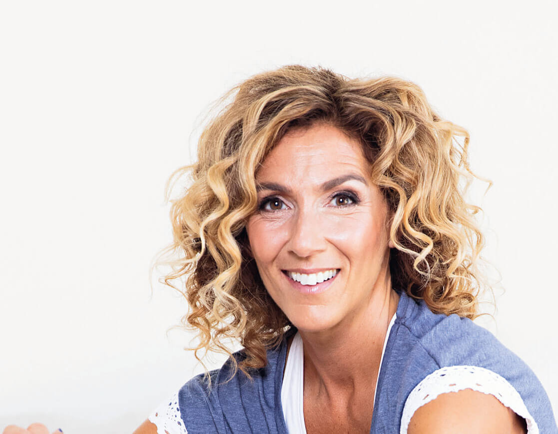 Kvinna med lockigt hår och kortärmad tröja