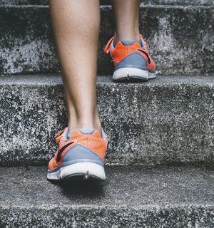 Fötter och ben på någon som går i en trappa