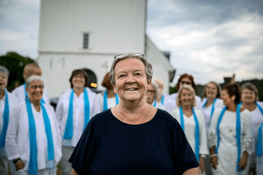 Kvinna framför kyrkokör och kyrka