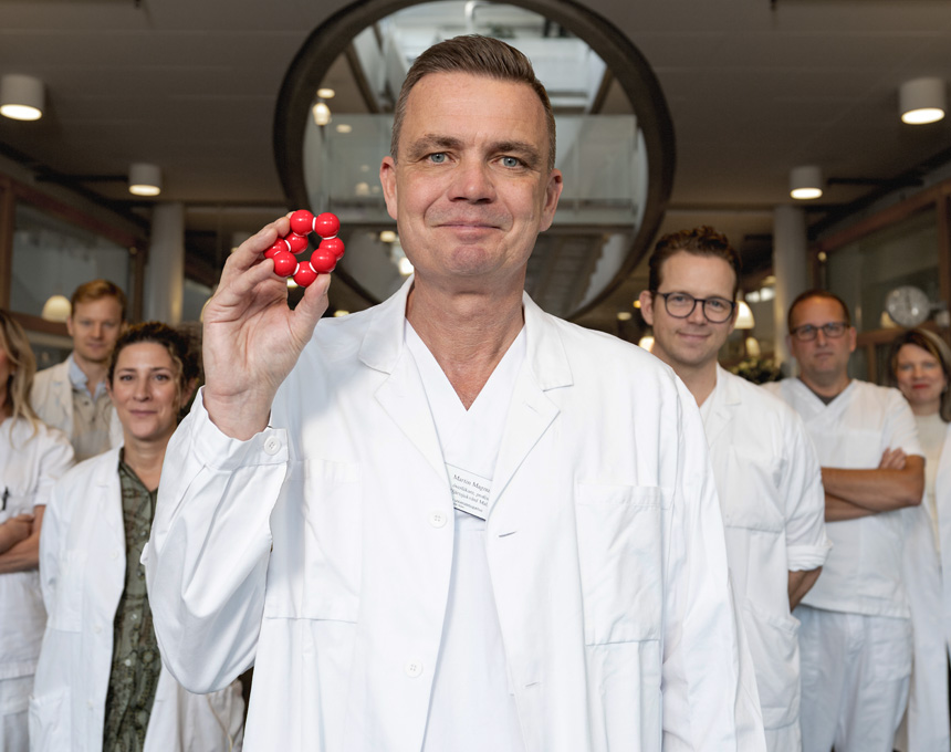 Martin Magnusson med forskarteam och molekyl i handen