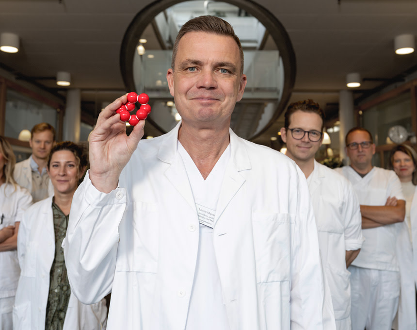 Martin Magnusson med forskarteam och molekyl i handen