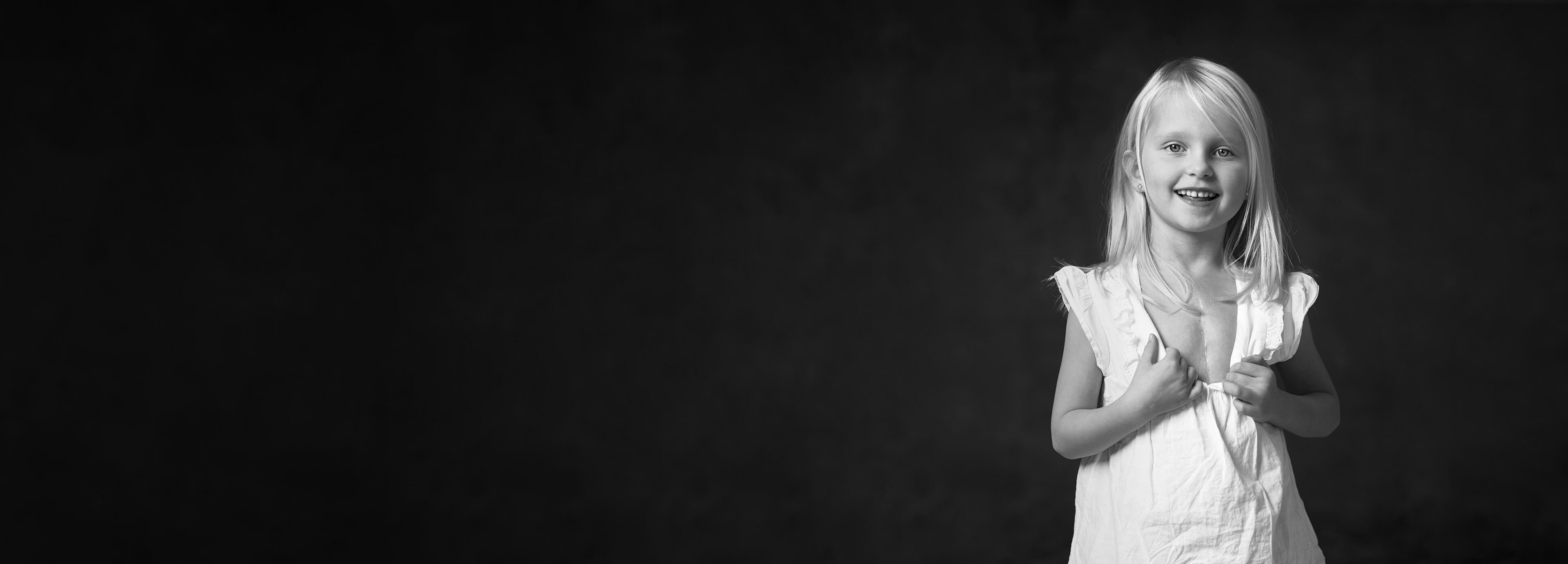 Flicka visar sitt ärr på bröstet