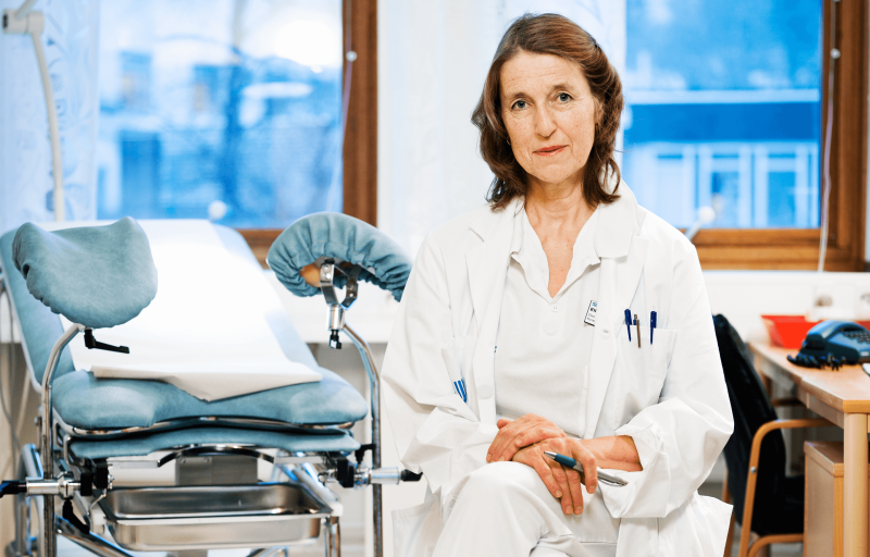 Kvinnlig läkare i vit rock i behandlingsrum