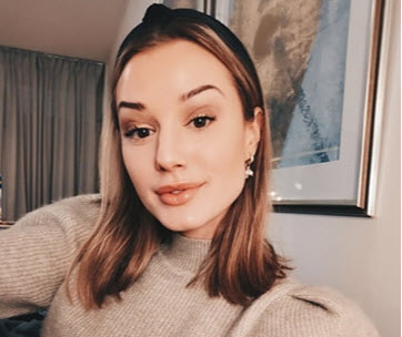 Ung kvinna med svart hårband framför en tavla