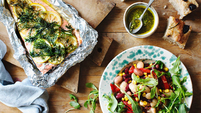 Grillad lax i folie och sallad i skål.