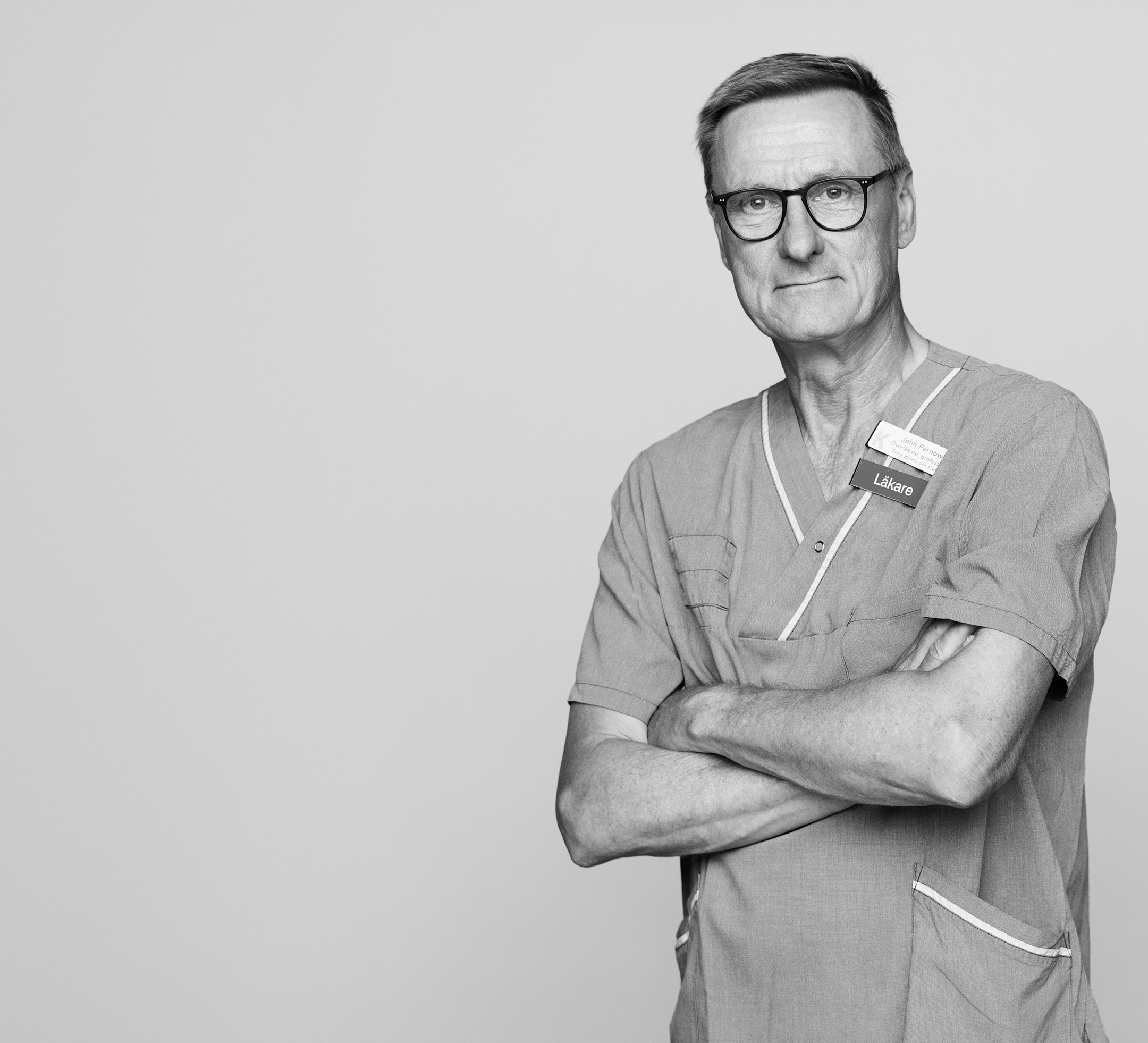 Pernow sitter på en stol med grå bakgrund. Företagsgåva. 