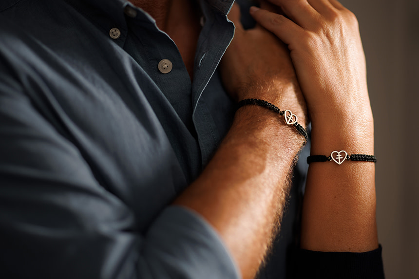 Närbild på två armar med armband med guldhjärtan.