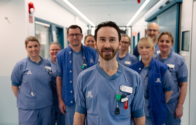 Forskare i läkarkläder står i korridor på sjukhus