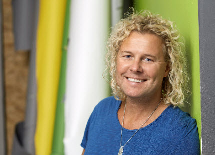 Man med blont lockigt hår och blå t-tröja