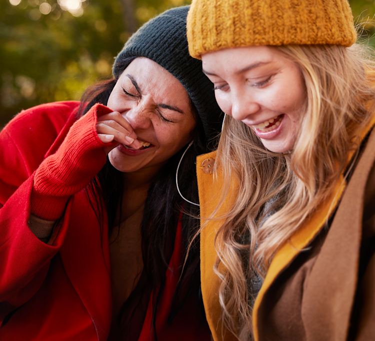 Två tjejer skrattar utomhus