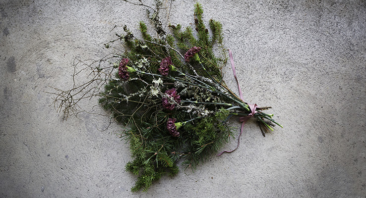 Vinterbukett med vintergröna kvistar och nejlikor.