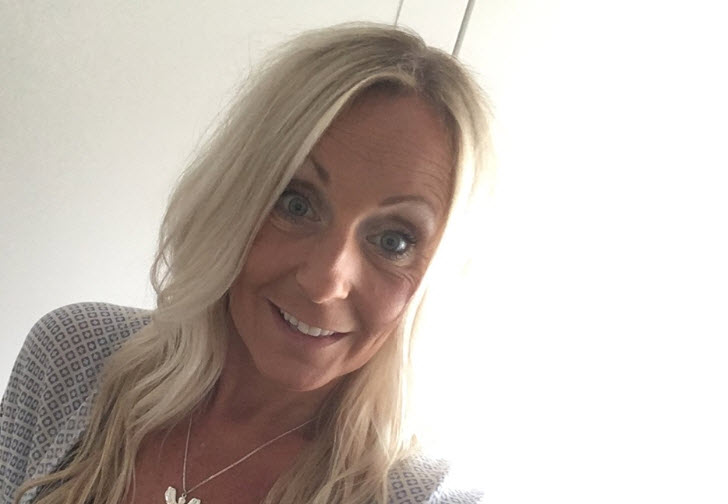 Kvinna med långt blont hår i inomhusmiljö