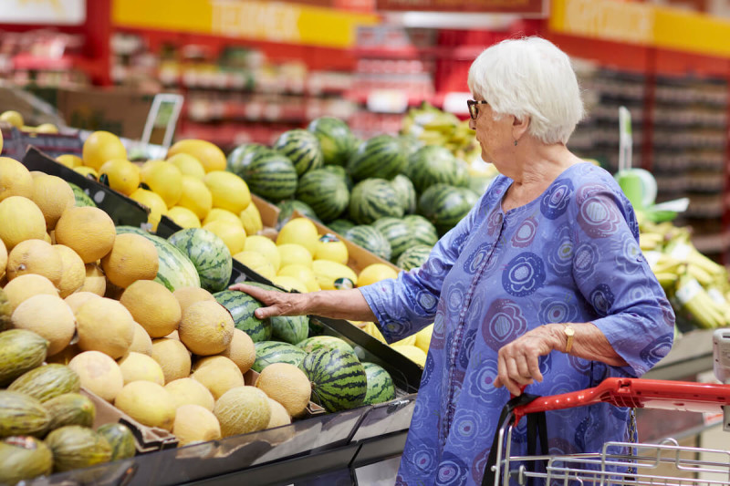 Äldre kvinna i livsmedelsbutik
