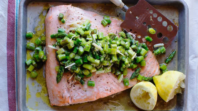 Lax med sparrissalsa och citroner på en plåt.