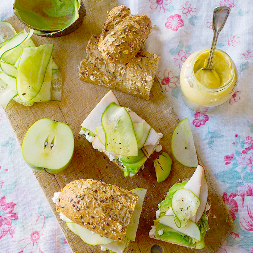 Smörgås med avokado och kalkon serverade på en skärbräda