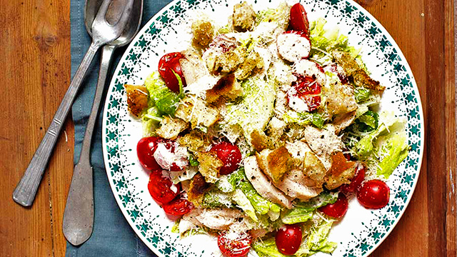 Ceasarsallad och krutonger uppdukade på fat