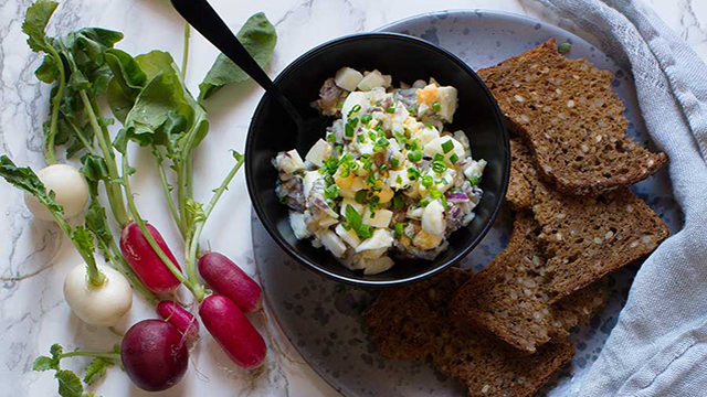 Gubbröra i en skål, med bröd bredvid på en tallrik.