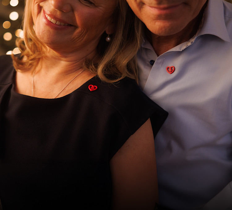 Par håller om varandra och båda har hjärtpin på sina tröjor