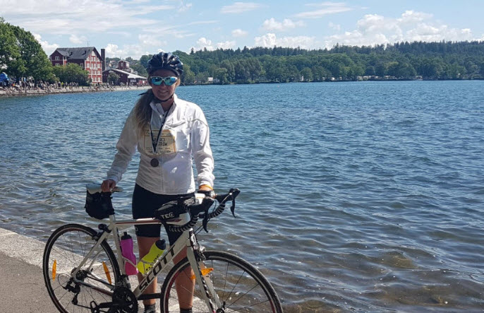 Kvinnlig cyklist med sin cykel på en kaj