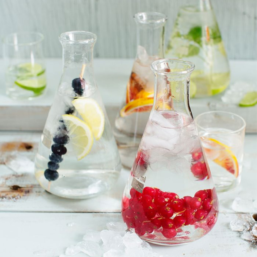 Olika bär i Erlenmeyerkolvar fyllda med vatten.