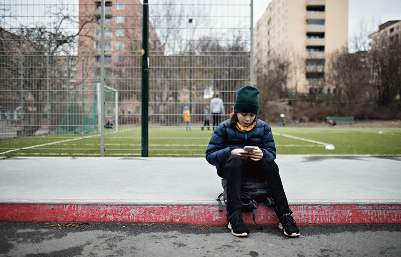 Ungdom tittar på sin mobil utomhus