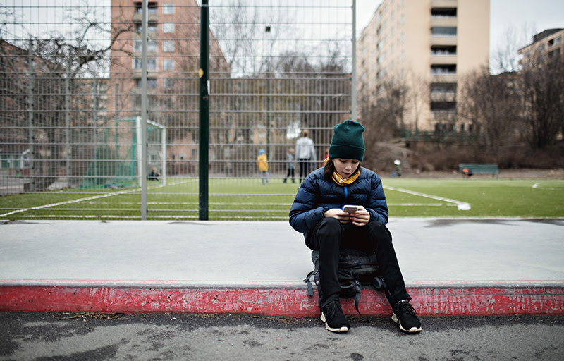 Ungdom tittar på sin mobil utomhus