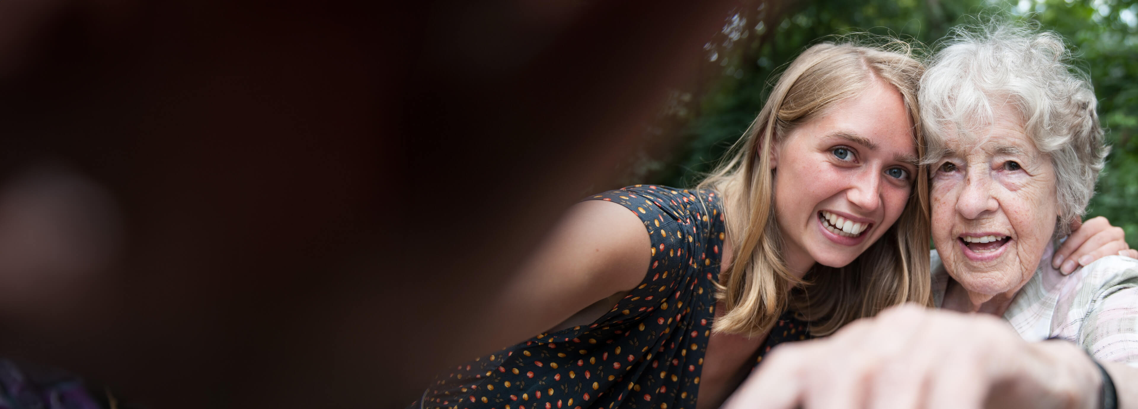 En ung och en äldre kvinna tar en selfie utomhus