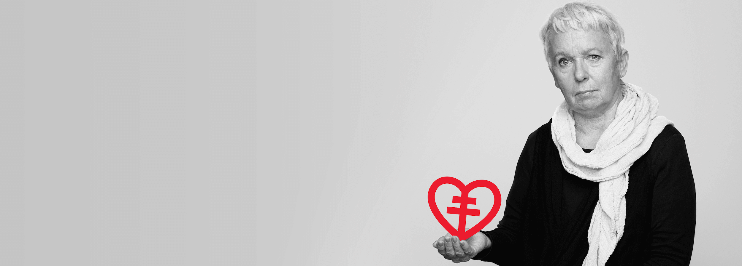 Lisbeth som förlorade sin son i plötsligt hjärtstopp håller i hjärt-lungfonden symbolen