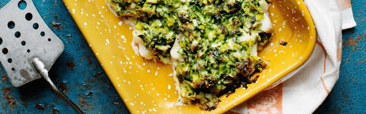 Torsk i gul ugnsform med en duk undertill. Stekspade ligger på bordet bredvid.