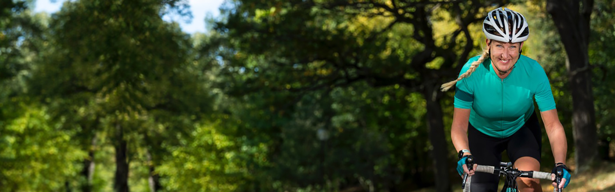 Glad cyklist på sommarväg.