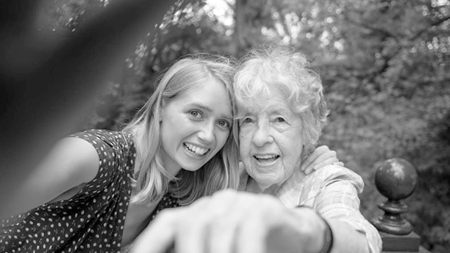 Äldre kvinna och barnbarn tar en selfie