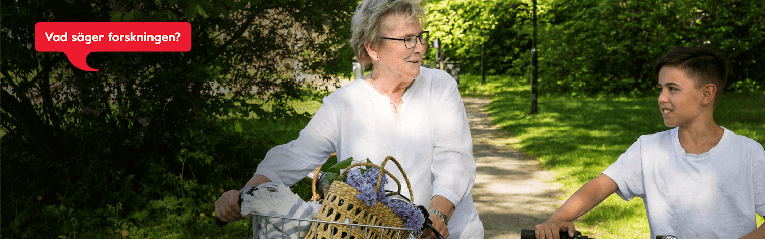 Kvinna och pojke pratar och leder cykeln på väg