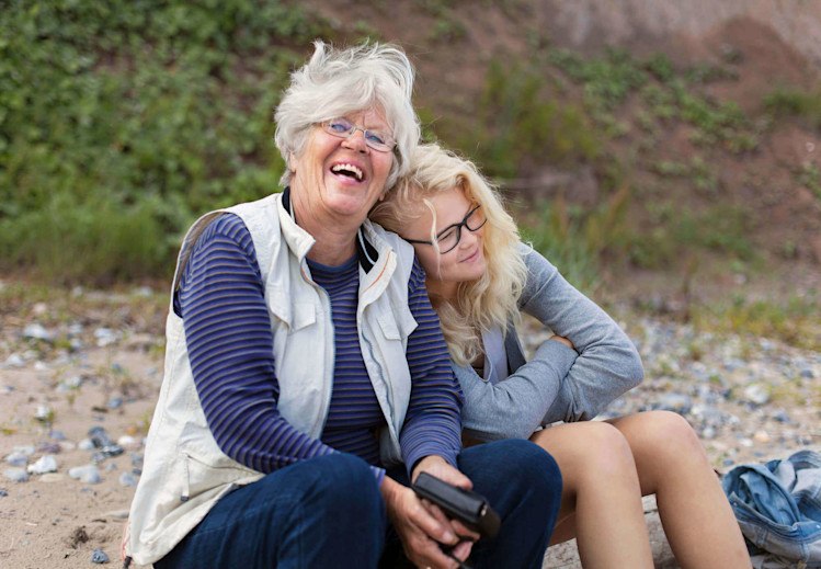 Kvinna med barnbarn på stranden