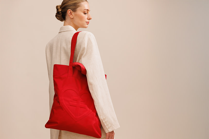 Kvinna bär Lars Wallins röda påse.