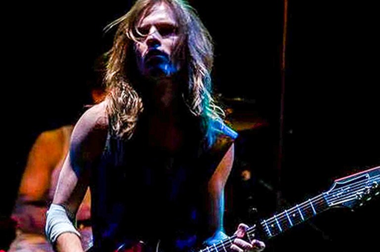 Manlig rockartist med långt hår och gitarr