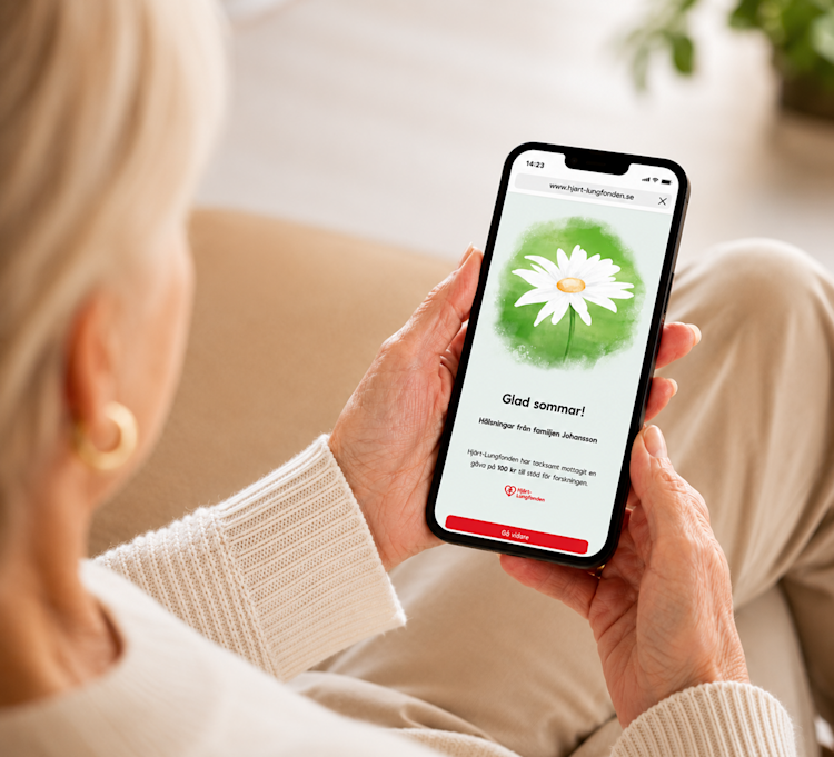Äldre kvinna håller i mobiltelefon