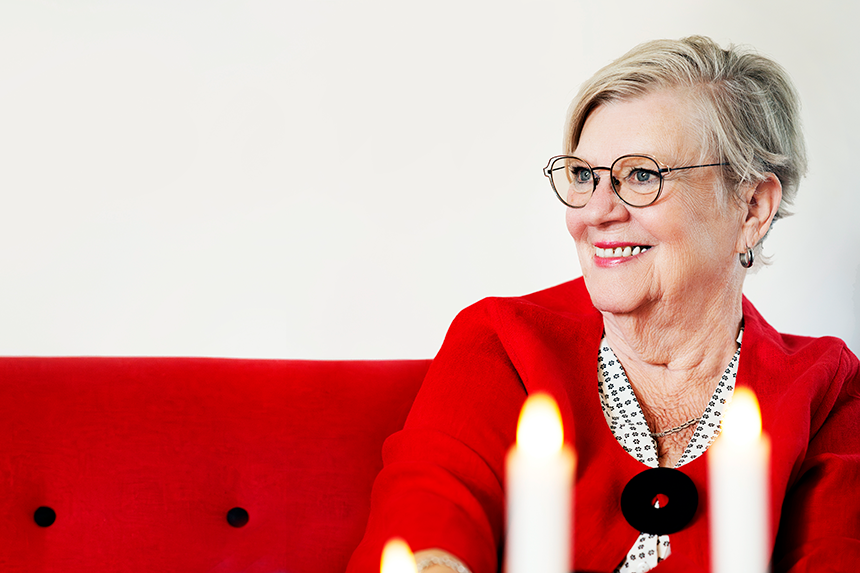 Gunbritt som drabbats av hjärtinfarkt sitter i soffan med levande ljus